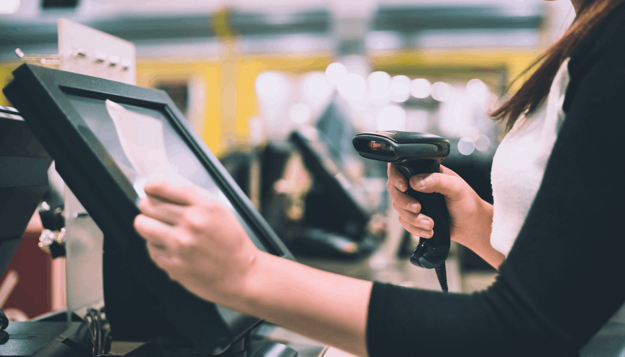 Cajera usando lector de códigos en sistema de punto de venta POS en tienda retail.