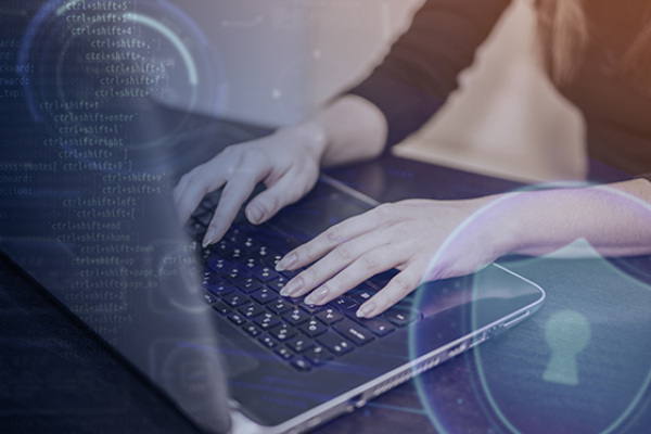 Manos escribiendo en portátil con interfaz de ciberseguridad, ilustrando protección IPS y defensa activa de la red.